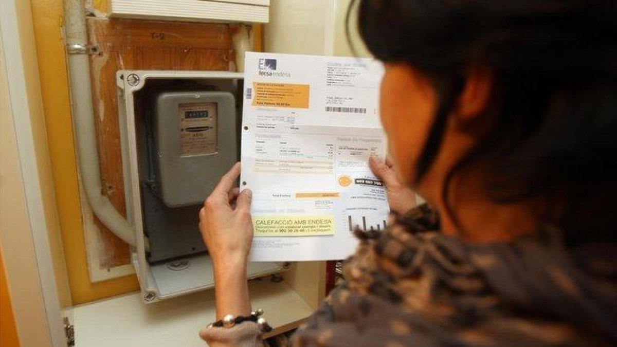 Una mujer consulta la factura de la luz.-DANNY CAMINAL