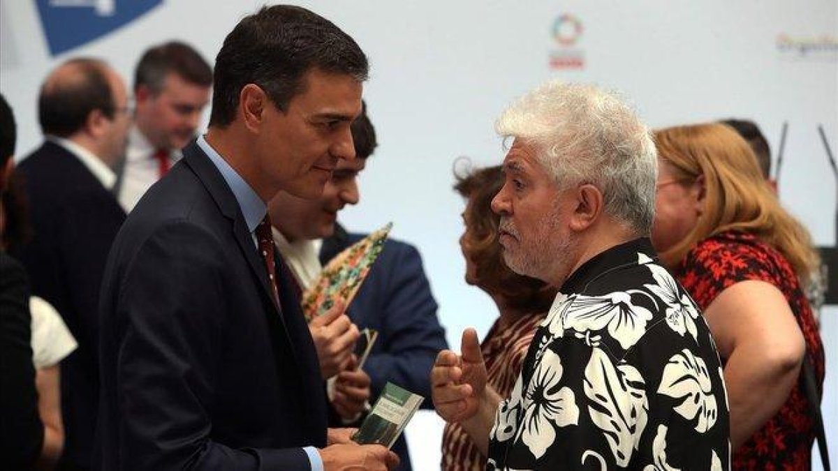 El presidente del Gobierno en funciones  Pedro Sánchez conversa con el cineasta Pedro Almodóvar.-KIKO HUESCA (EFE)