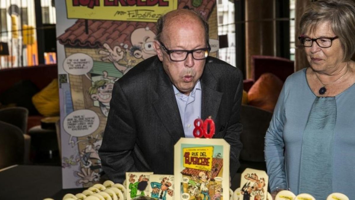 El dibujante Francisco Ibáñez sopla junto a su mujer las velas del pastel de su 80º cumpleaños, en el que aparecen sus inolvidables Mortadelo y Filemón y la portada del integral de '13, Rue del Percebe' alzada sobre un enorme tebeo con una doble página de-JOAN PUIG