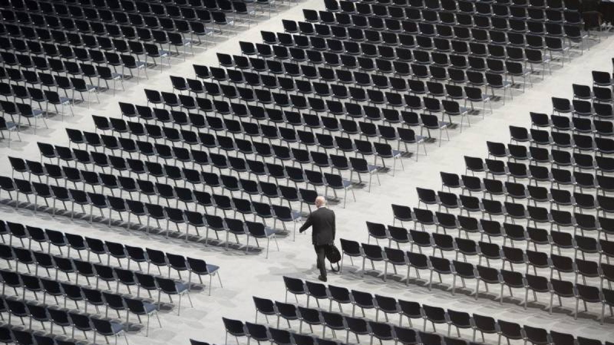 Un asistente camina entre los asientos vacíos de la junta general de accionistas de Siemens en Múnich (Alemania).-Foto: EFE/ ARCHIVO