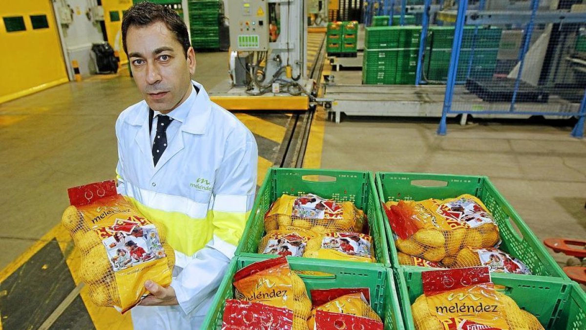 Javier Meléndez, con una de las bolsas de cinco kilos recién salida de la línea de produccion de la fábrica de Patatas Meléndez en Medina del Campo.-J. M. LOSTAU