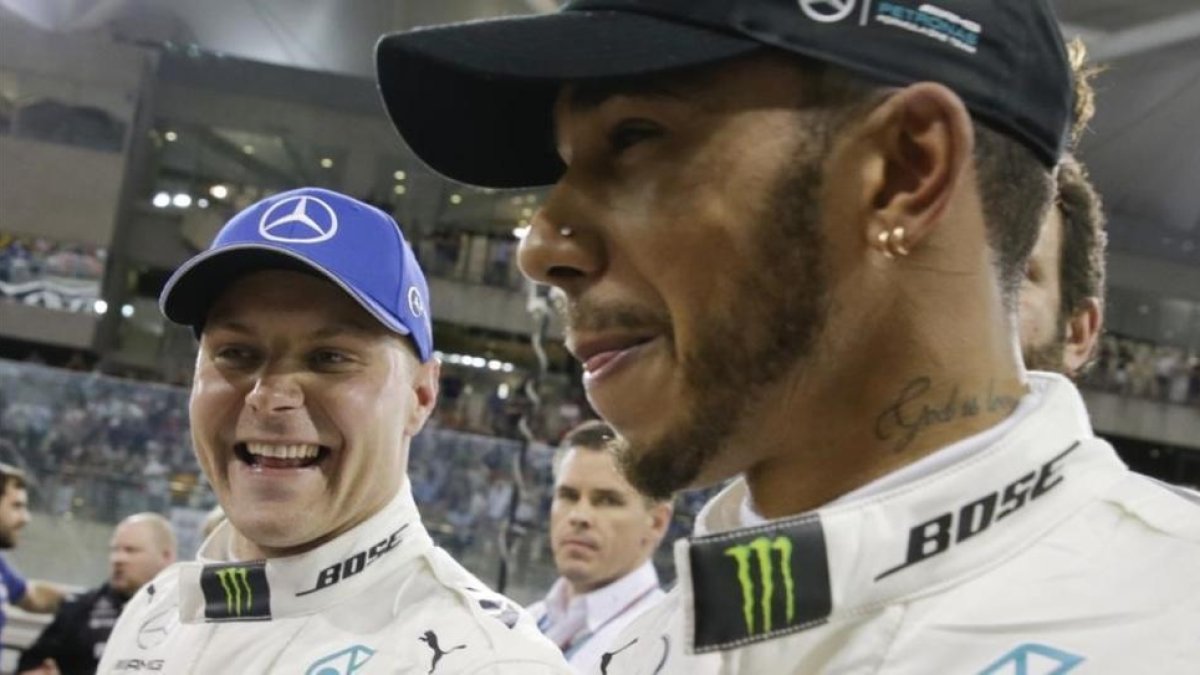 Valtteri Bottas y Lewis Hamilton sonrien tras lograr el finlandés la última pole de la temporada en Abu Dabi.-AP
