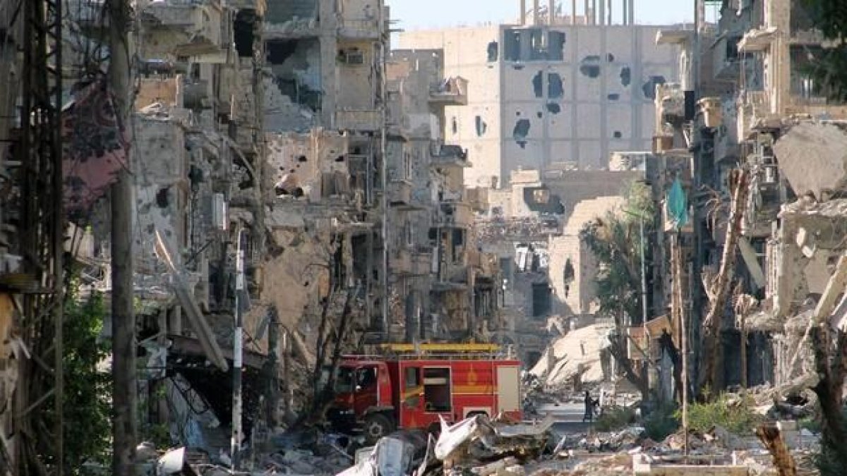 Un camión de bomberos en medio de un paisaje de destrucción en Deir Ezzor, en septiembre del 2013.-AFP / AHMAD ABOUD