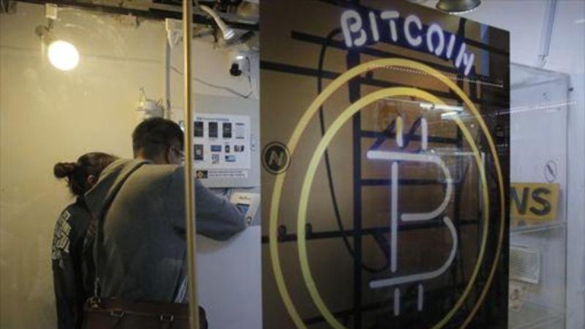 Dos clientes en un Bitcoin ATM de Hong Kong, el pasado sábado.-AP / KIN CHEUNG