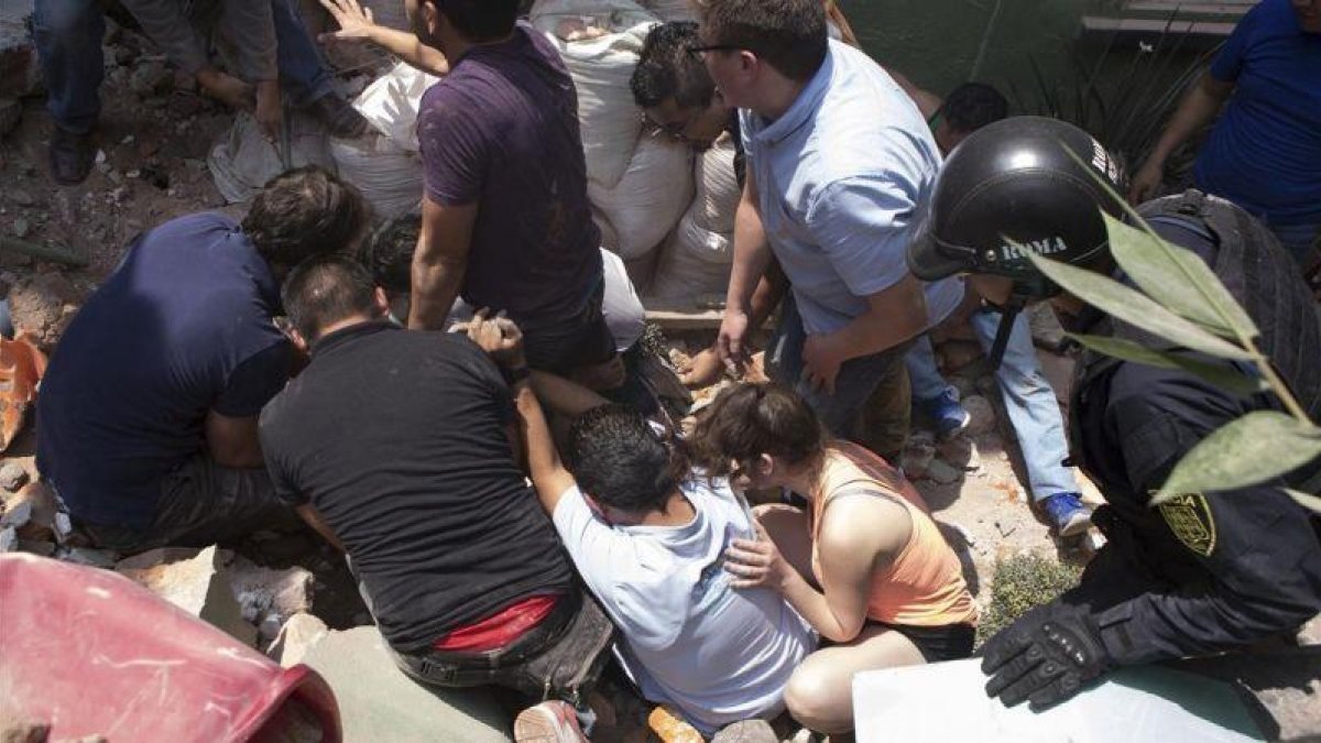 Los equipos de rescate sacan con vida a un hombre de entre los escombros.-AP / PABLO RAMOS