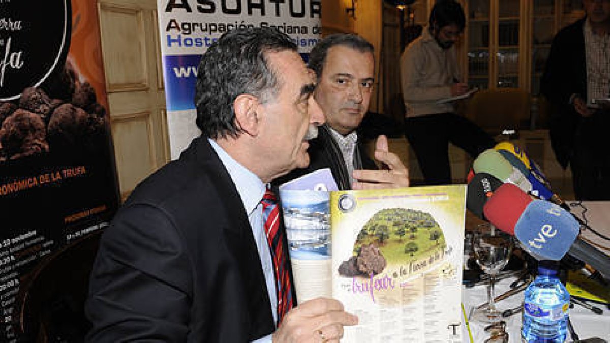 Anselmo García, de Soriactiva, muestra la revista en presencia de Ángel Mayor, presidente de Asohtur. / VALENTÍN GUISANDE-