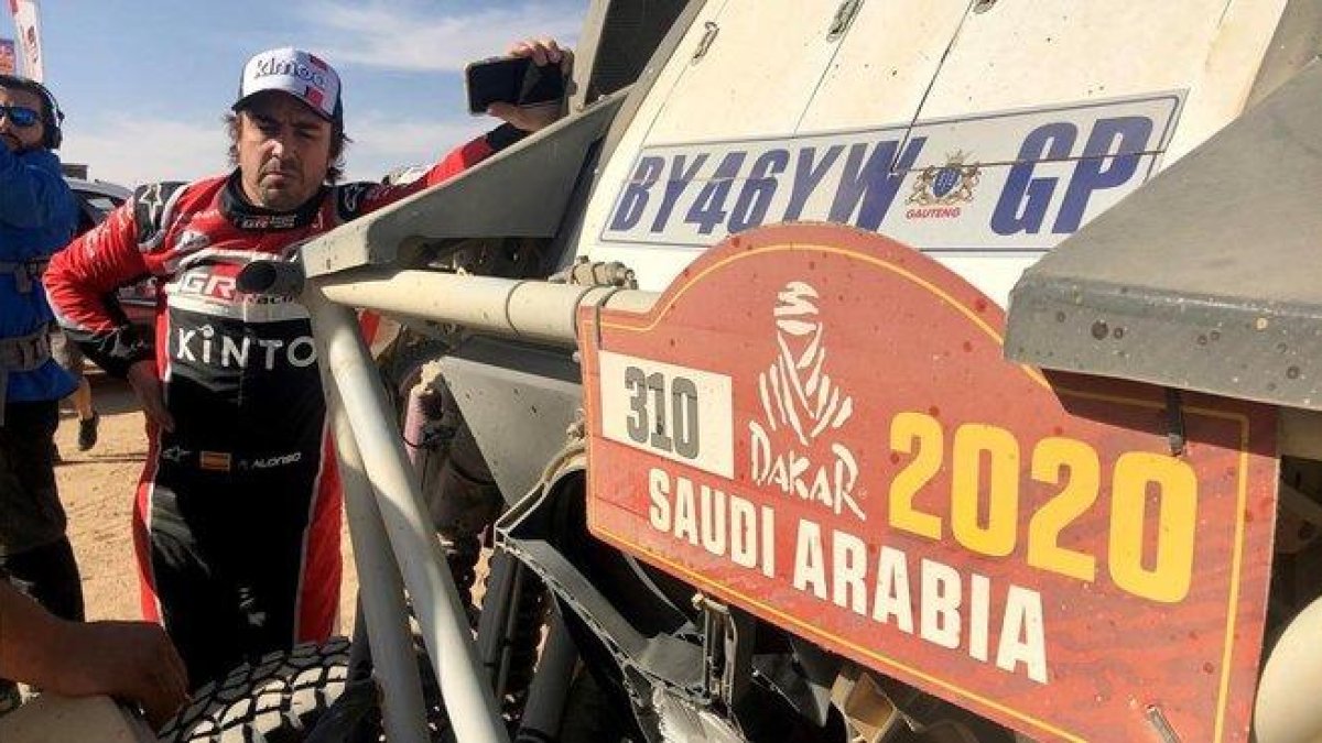 Fernando Alonso observa cómo reparan su Toyota.-EFE / FERNANDO GIMENO