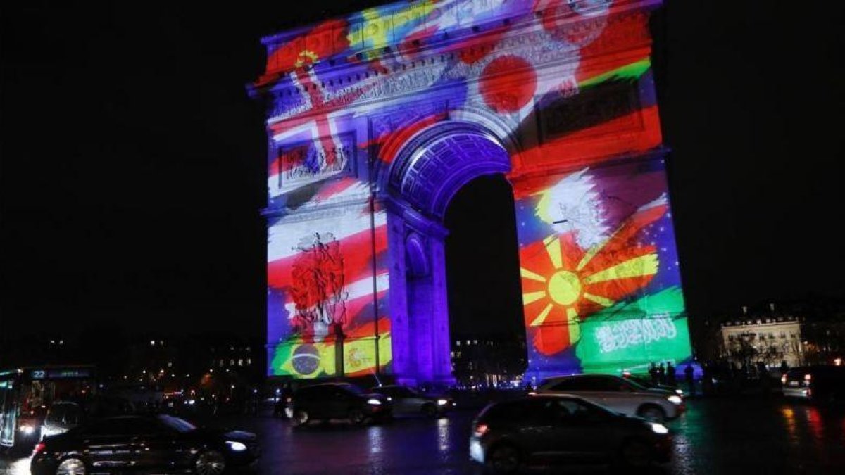 El Arco del Triunfo de París, iluminado con las banderas de los países participantes en el Mundial.-AP / THOMAS SAMSON