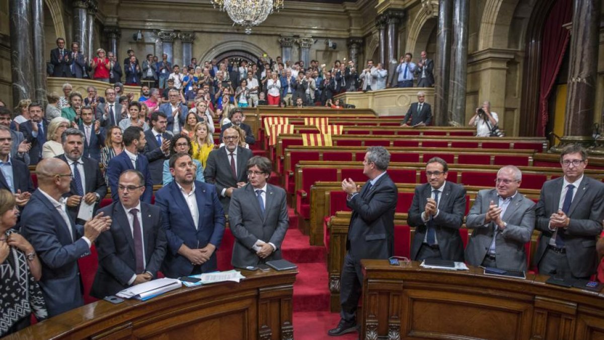 El Govern y los diputados de Junts pel Sí y la CUP, tras la aprobación de la ley del referéndum con el Parlament medio vacío.-FERRAN SENDRA