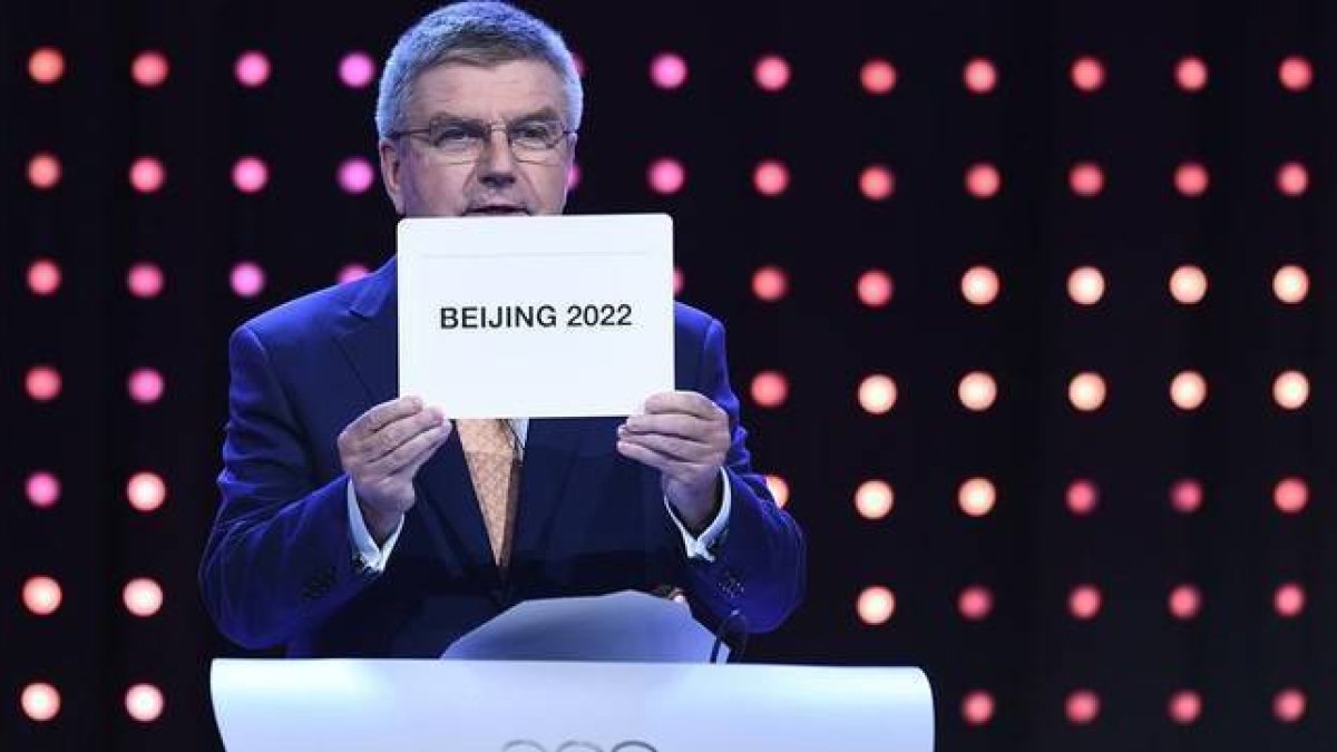 El presidente del Comité Olímpico Internacional, Thomas Bach, muestra el nombre de ciudad escogida como sede de los JJOO de invierno de 2022-Foto: AFP / MANAN VATSYAYANA