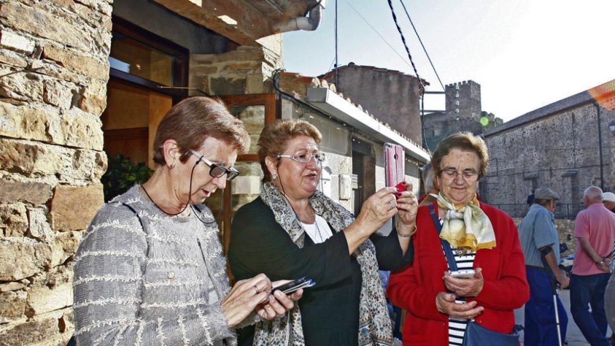 Vecinos comprobando la conexión a internet con sus dispositivos móviles-M.T.