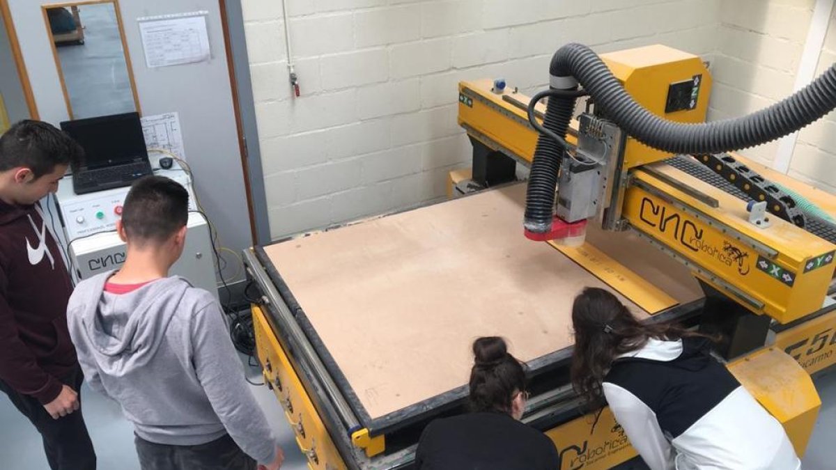 Alumnos del Pico Frentes junto a una máquina CNC.-HDS