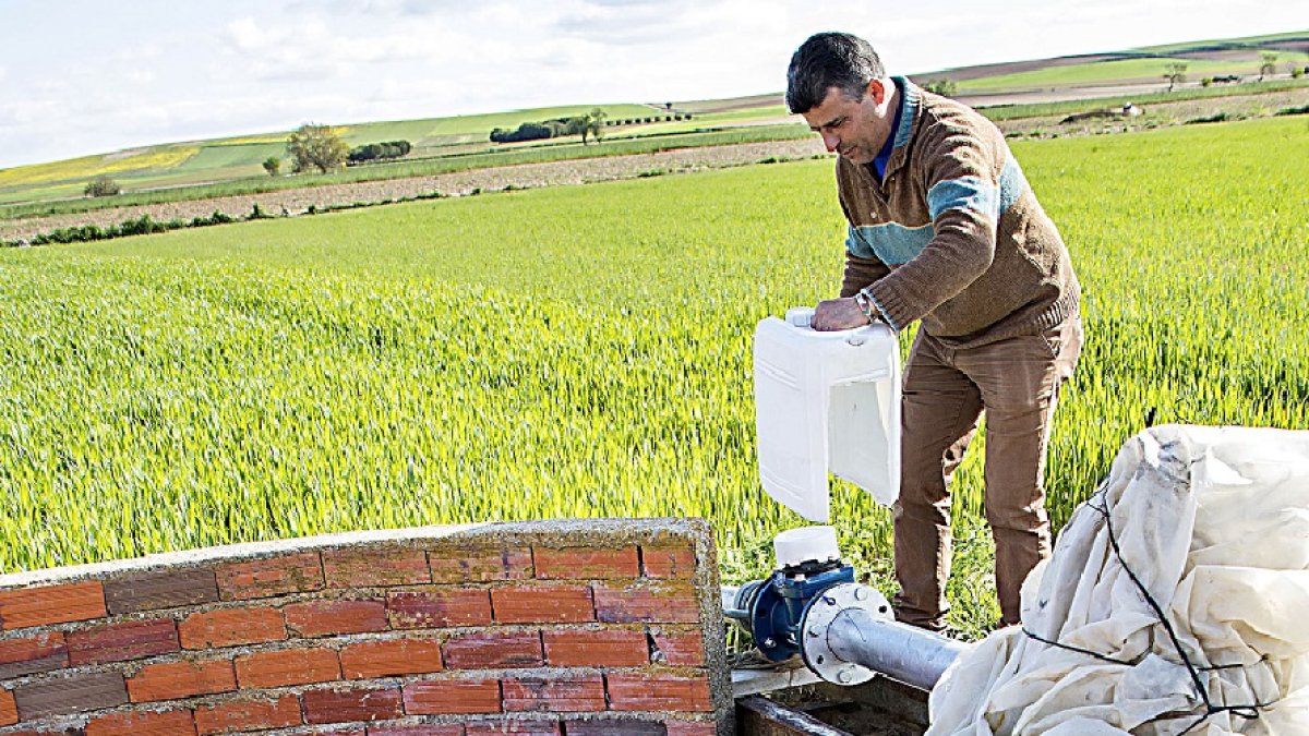 Un agricultor junto a un pozo.