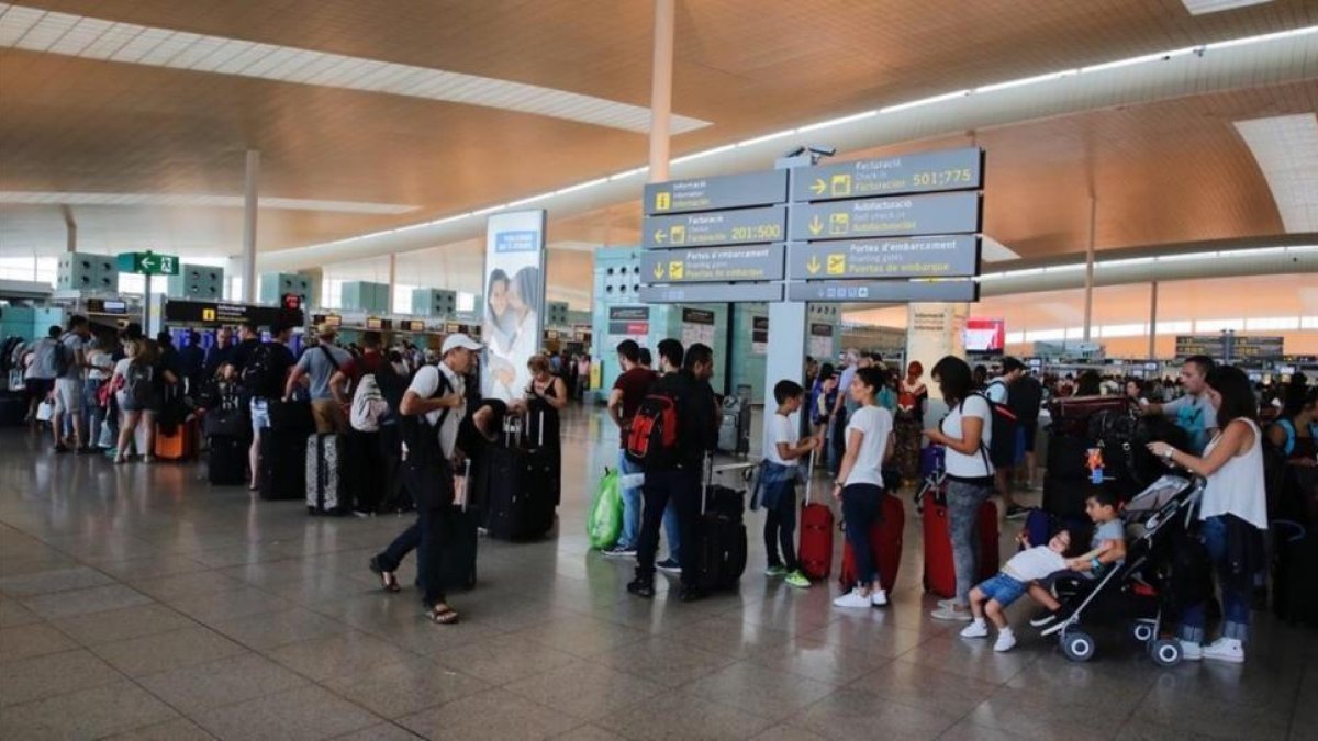 Colas esperando para llegar al mostrador de check in de Vueling el verano pasado.-
