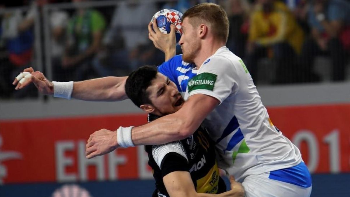 El lateral español Alex Dujshebaev choca contra el pivote esloveno Blagotinsek-/ GEORGI LICOVSKI (EFE)