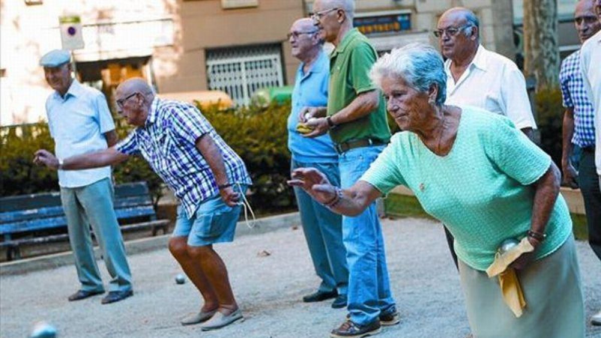 Un grupo de pensionistas juega a petanca en un parque de Barcelona.-ALBERT BERTRAN