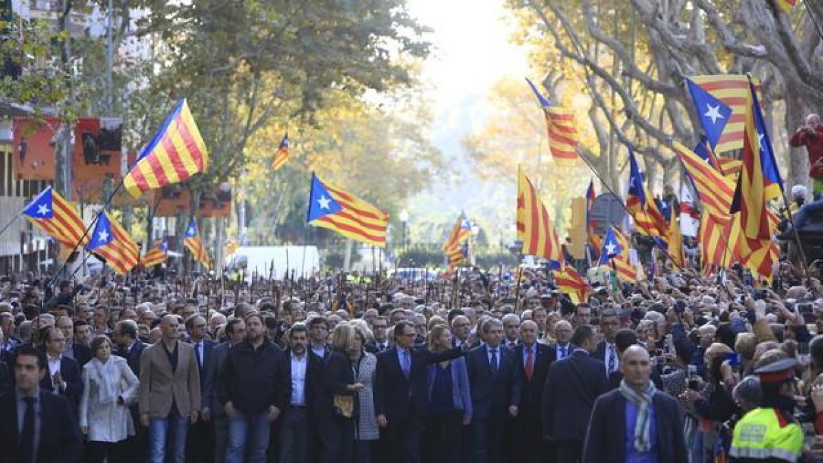 Mas, arropado por el Govern y alcaldes, saluda a la llegada al TSJC, en el paseo Lluís Companys.-FERRAN NADEU