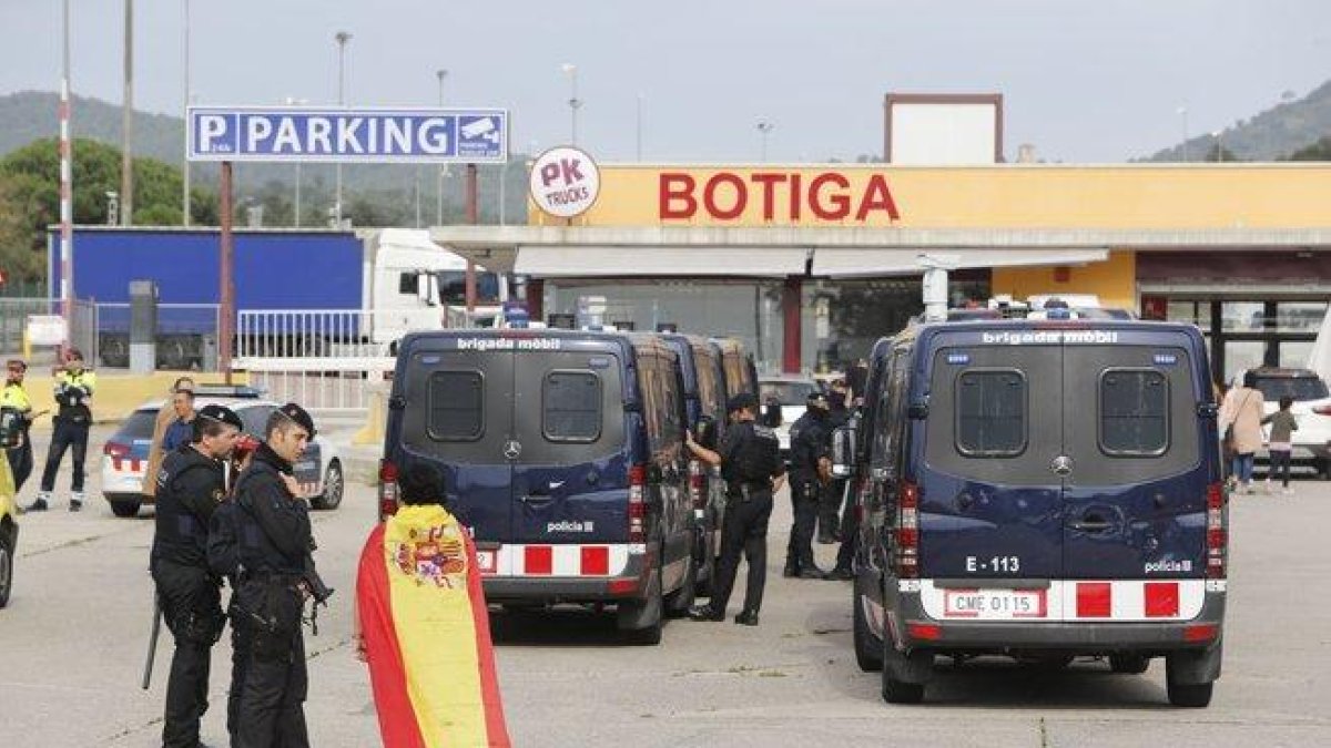 Una mujer con la bandera española habla con los Mossos, en la frontera con la Junquera.-JOAN CASTRO / ICONNA