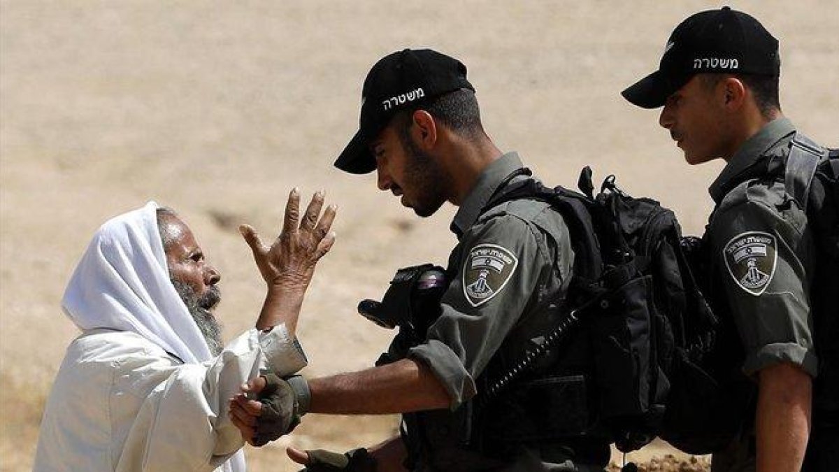 Un palestino discute con soldados israelís el pasado junio al sur de Hebrón.-EFE