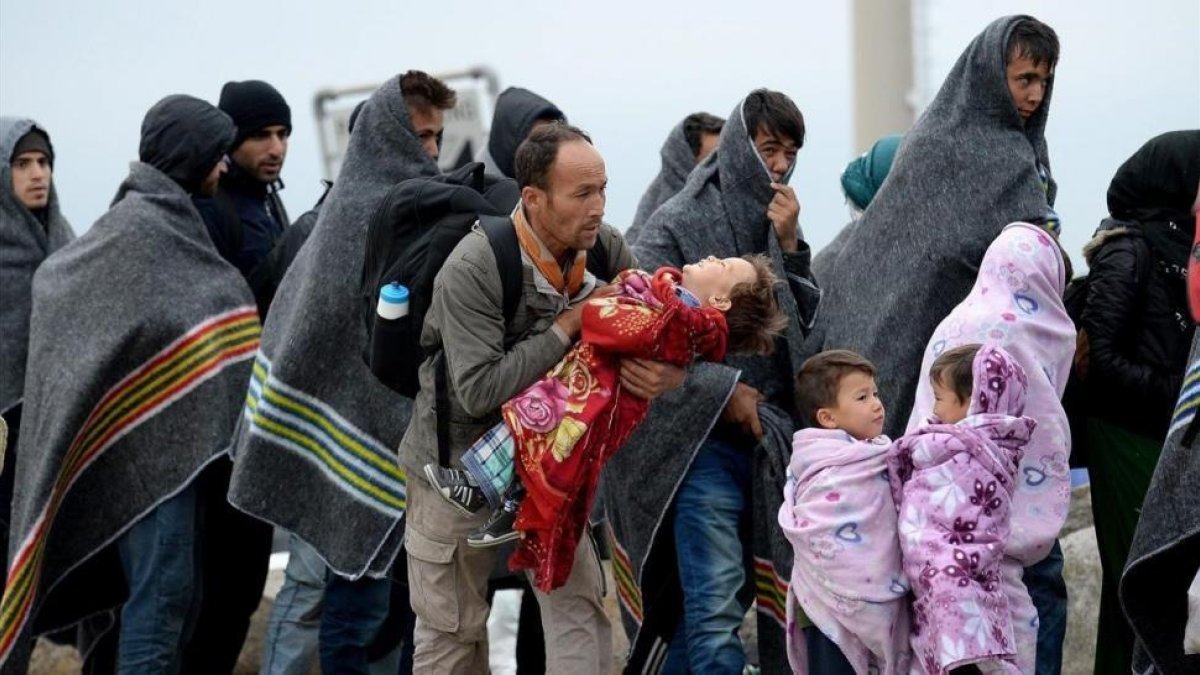 Refugiados se cubren con mantas tras cruzar la frontera entre Hungria y Austria en Nickelsdorf, Austria, en septiembre del 2015.-EFE / ROLAND SCHLAGER