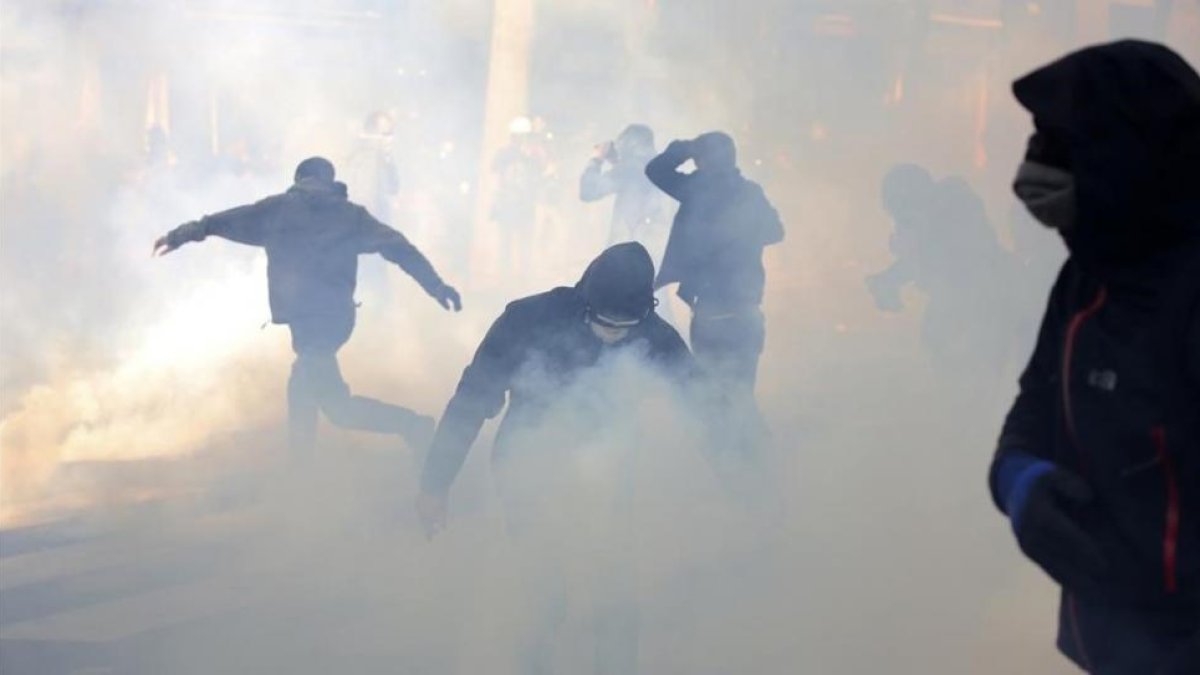 Jóvenes encapuchados lanzan cóctels molotov en la manifestación del Primero de Mayo en París.-AP / THIBAULT CAMUS