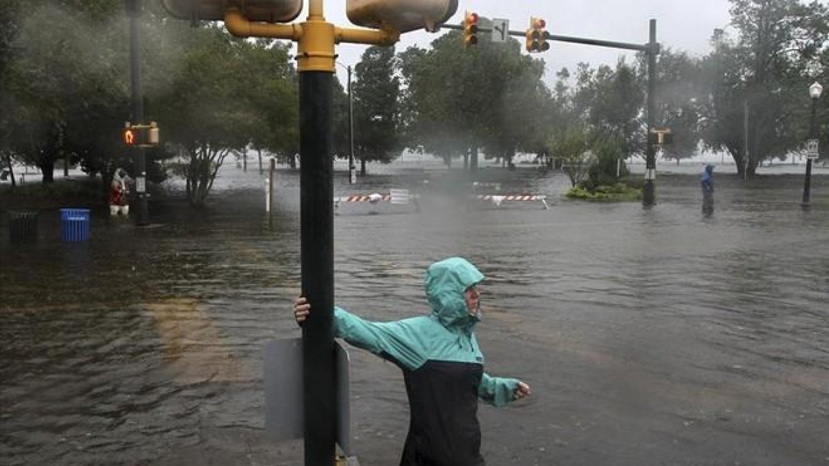 Una mujer camina por una calles inundadas por los efectos del huracán Florence, en la localidad de New Bern, en North Carolina.-AP