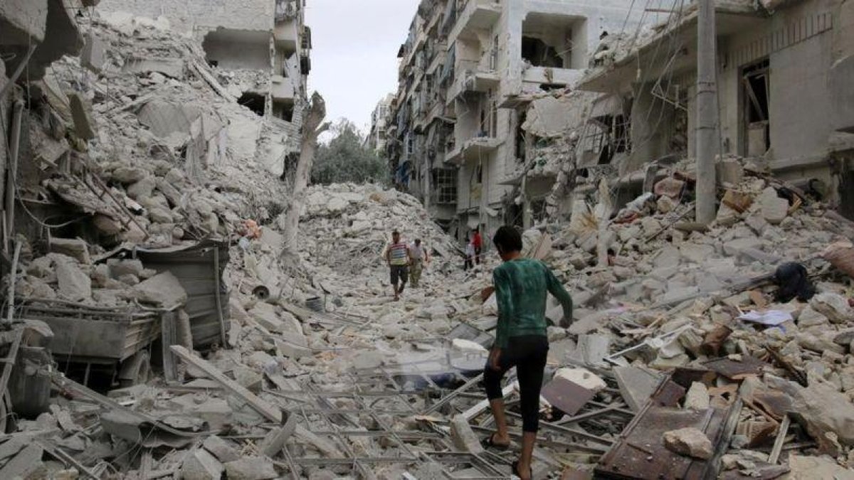 Varias personas inspeccionan los daños tras los bombardeos sobre el barrio de Tariq al-Bab, en manos rebeldes, en Alepo, este viernes.-REUTERS / ABDALRHMAN ISMAIL