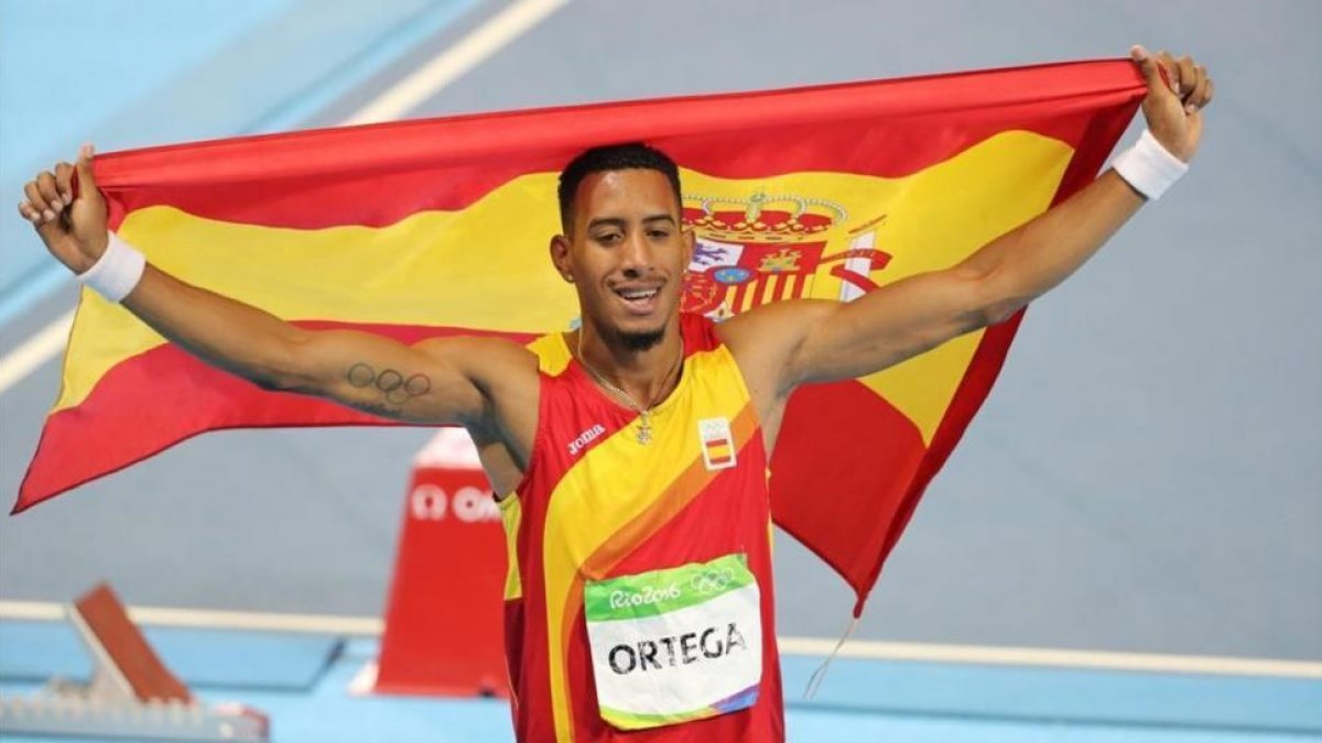 Orlando Ortega, paseando la bandera española.-EFE / ANTONIO LACERDA