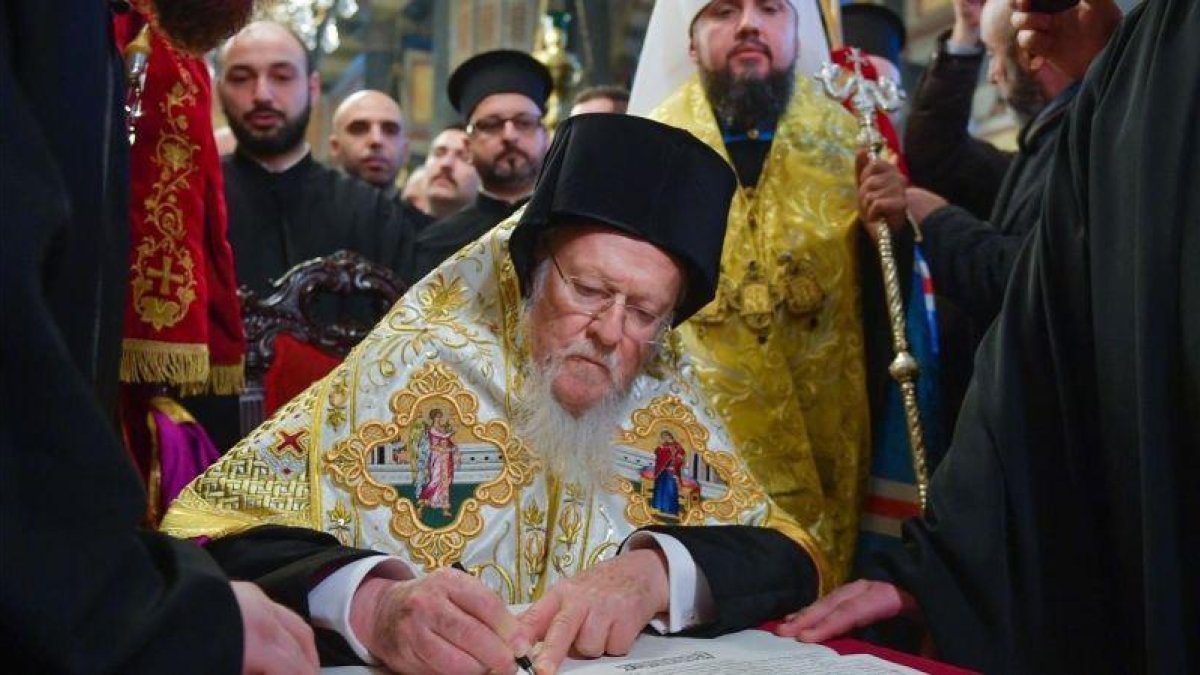 El patriarca Bartalomeo I firma el documento de escisión en la iglesia de San Jorge, en Estambul.-EFE / MYKOLA LAZARENKO