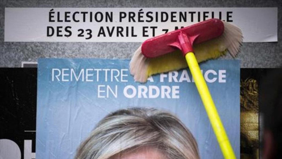 Un empleado del Frente Nacional pega un cartel electoral de Marine Le Pen al inicio de la campaña.-AFP / LIONEL BONAVENTURE