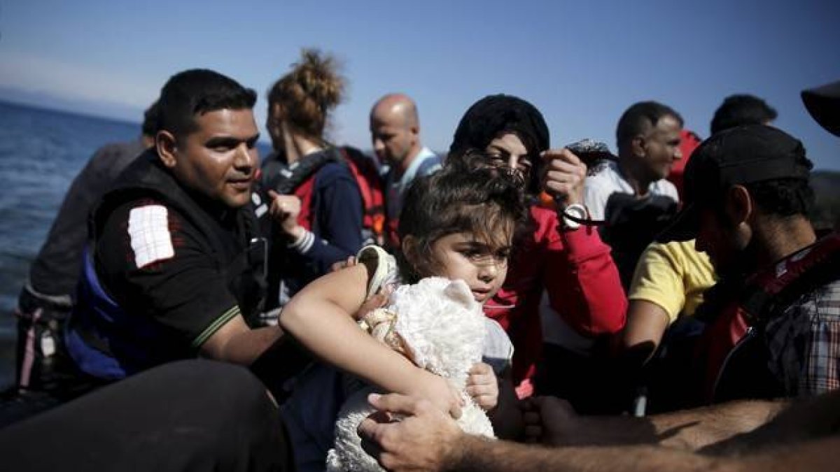 Una niña siria es ayudada a bajar de su embarcación en la isla griega de Lesbos, este sábado.-Foto:  REUTERS / ALKIS KONSTANTINIDIS