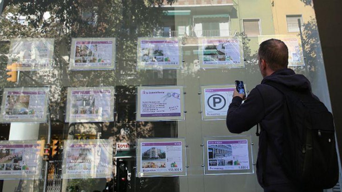 Hombre busca un piso de alquiler en una inmobiliaria de Barcelona.-ELISENDA PONS