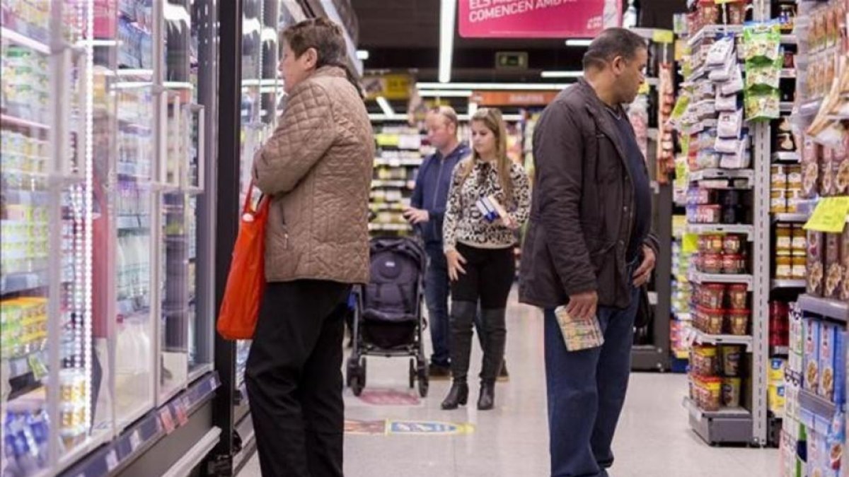 Un grupo de personas comprando en un supermercado en Barcelona.-FERRAN NADEU