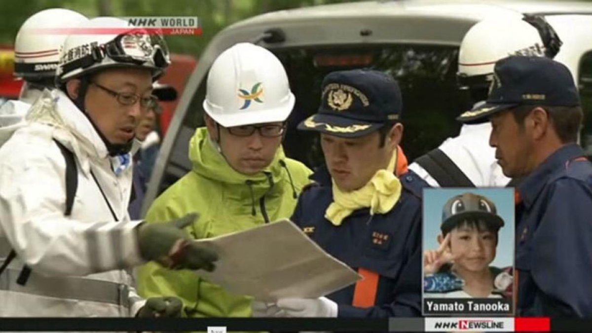 Agentes de policía buscan al pequeño Yamato Tanooka, en la esquina inferior derecha.-NHK