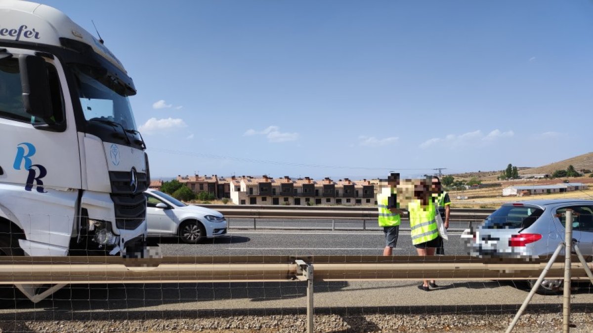 Dos conductores departen con un agente de la Policía Local con los vehículos parados en la variante. A.C.