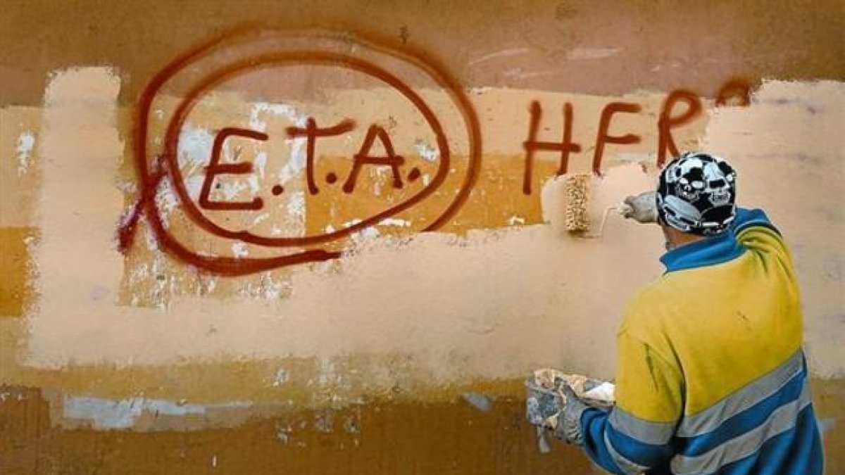 Un técnico de limpieza borra una pintada a favor de ETA en Gernika (Vizcaya), el día después de que la banda terrorista anunciase el cese definitivo de sus acciones armadas.-/ REUTERS / VINCENT WEST