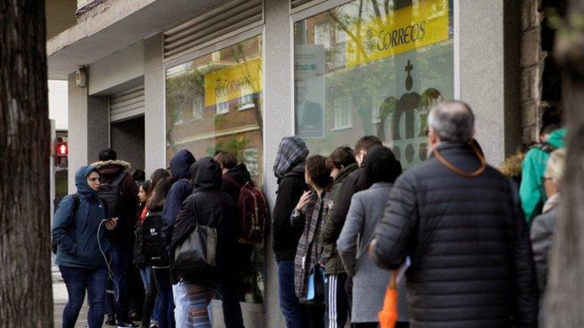 Decenas de personas hacen cola en una oficina de Correos para votar en las elecciones generales.-CARLOS PÉREZ (EFE)