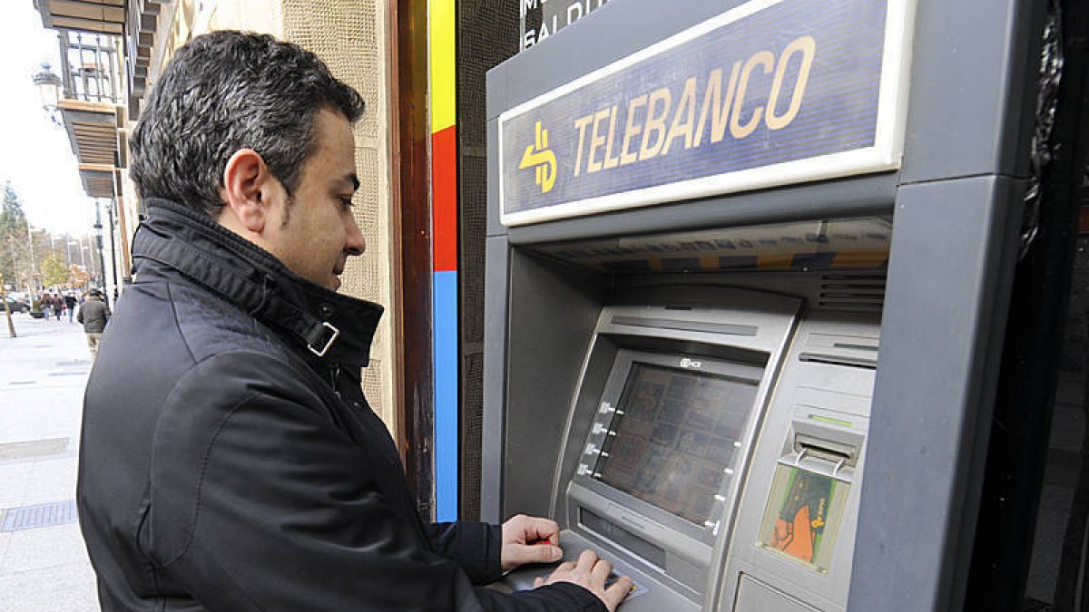 Un hombre hacía uso la pasada jornada del cajero automático situado en el Collado. / VALENTÍN GUISANDE-