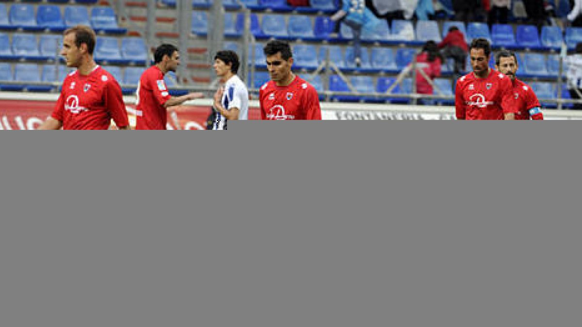 Varios jugadores del Numancia abandonan el césped cabizbajos tras perder ante el Recre. / VALENTÍN GUISANDE-