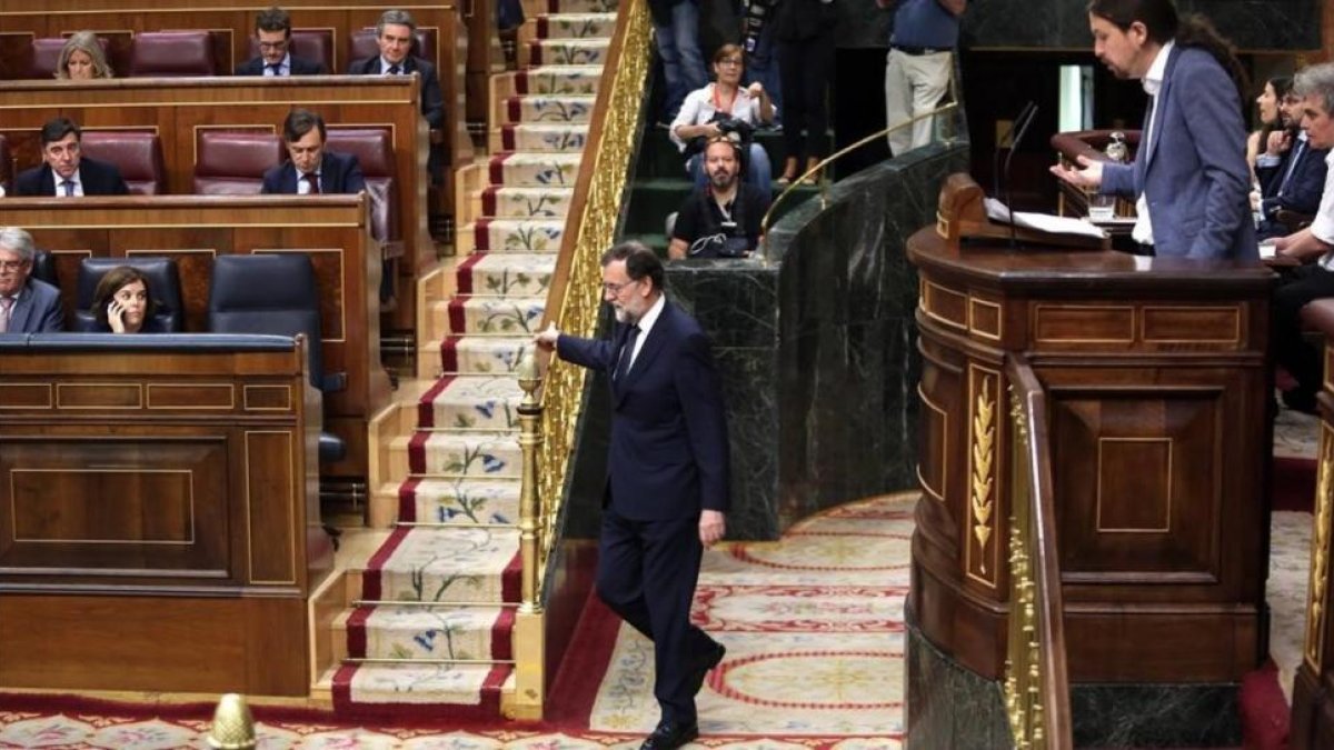Mariano Rajoy vuelve a su escaño durante la intervención de Pablo Iglesias en la moción de censura.-JUAN MANUEL PRATS
