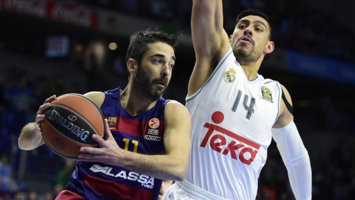 El pívot madridista Ayón intenta frenar una acción de Navarro en un partido de Liga-JAVIER SORIANO / AFP