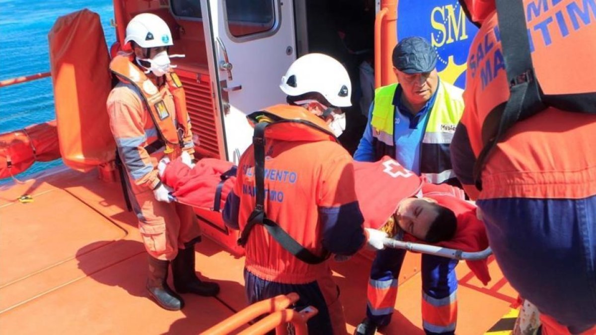 Miembros de Salvamento Marítimo atienden a una de las personas rescatadas en el Estrecho.-A CARRASCO RAGEL