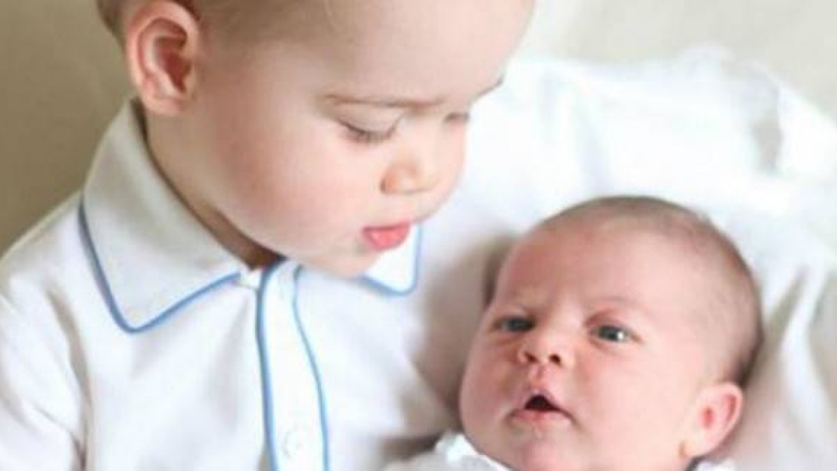 Carlota, en brazos de su hermano mayor, Jorge; los hijos de los duques de Cambridge.-Foto: @KensingtonRoyal
