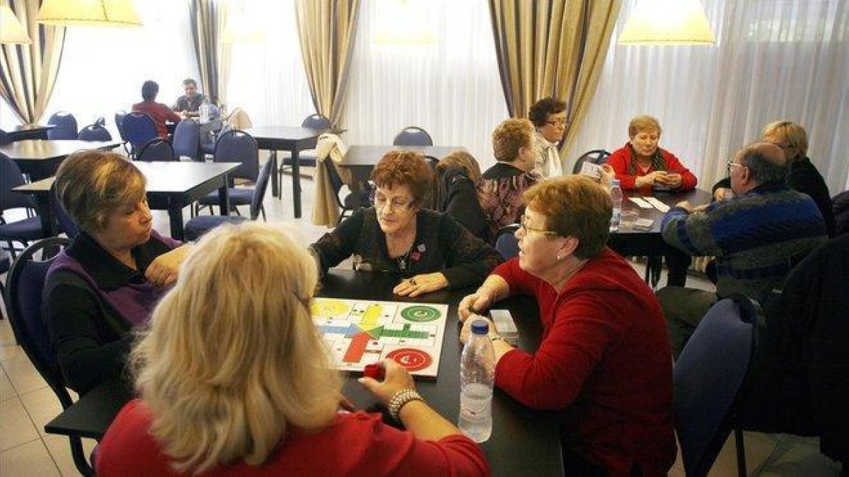 Clientes de la Imserso pasan el rato jugando al parchís en un hotel.-DAVID BORRAT (CLICK ART)