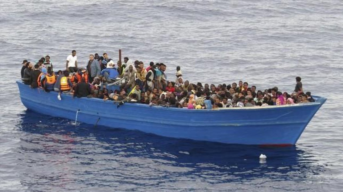 Un grupo de inmigrantes en una embarcación precaria a la espera de ser rescatados en el Mediterráneo, el 28 de octubre del 2015.-EFE