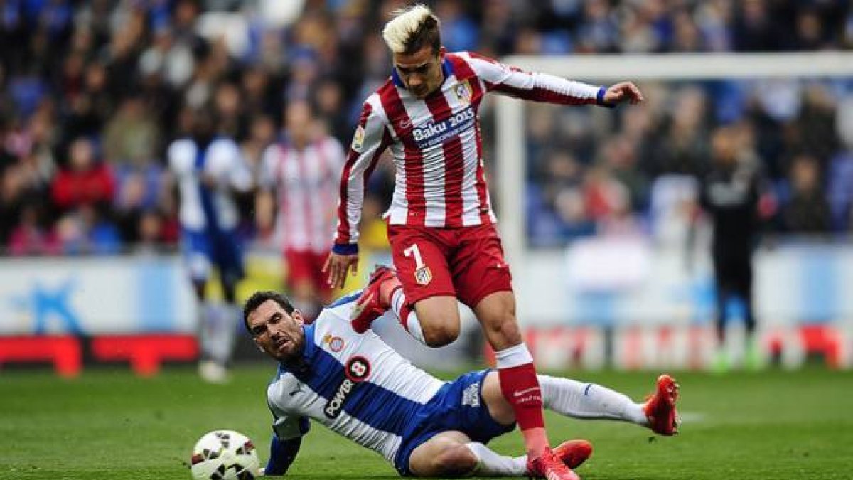 Abraham y Griezmann peleam por el balón, en un momento del partido que ha enfrentado al Espanyol y el Atlético en Cornellà.-Foto: AP / MANU FERNÁNDEZ