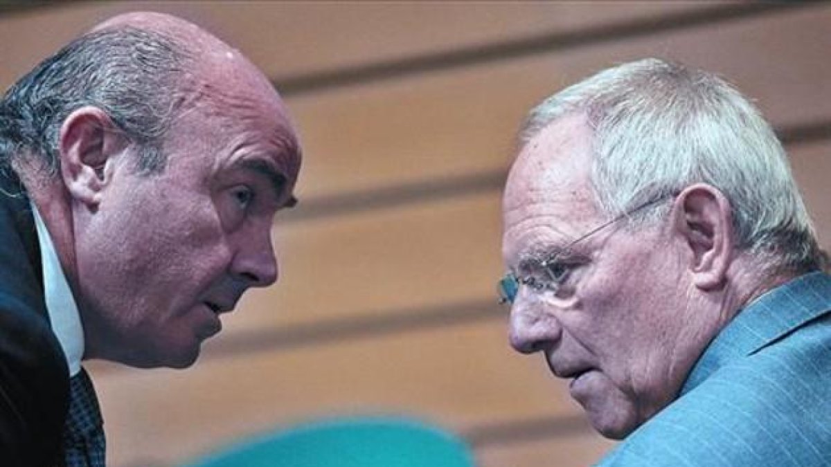 Guindos, con su homólogo alemán Wolfgang Schauble, en una reunión del Ecofin en Bruselas.-AFP PHOTO / GEORGES GOBET