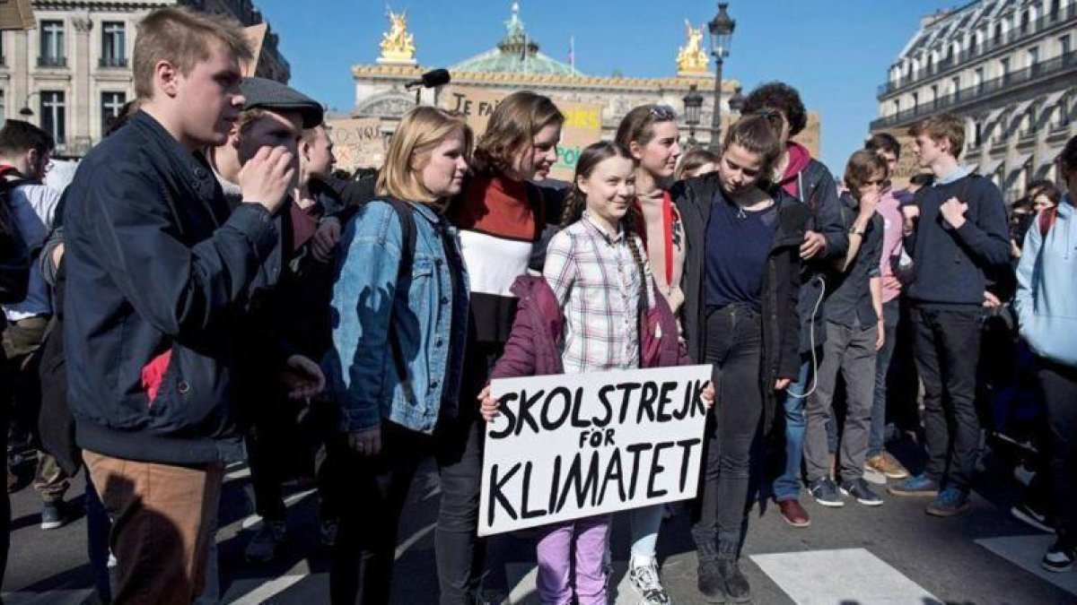 La activista sueca Greta Thunberg sostiene una pancarta junto a varios estudiantes franceses que participan en una marcha contra el cambio climático en París, el 22 de febrero.-EFE / JULEN DE LA ROSA
