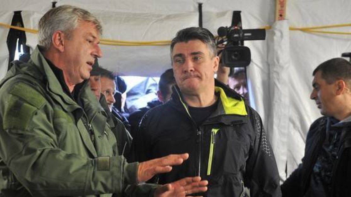 El primer ministro croata, Zoran Milanovic, en el centro, durante su visita al campo de refugiados de Opatovac.-AFP/ELVIS BARUKCIC