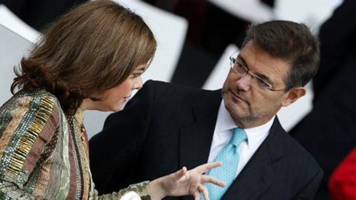 El ministro de Justicia, Rafael Catalá, con la vicepresidenta Soraya Sáenz de Santamaría, este lunes, en el desfile militar en Madrid.-EFE / JAVIER LIZÓN